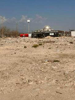 Ön planda belli bir mahalle kadar geniş boşluk. Yıkıntıların iş makinaları ile toplandığı, bomboş kalmış bir moloz tarlası. Uzakta metal kubbesi parlayan minaresiz bir cami.