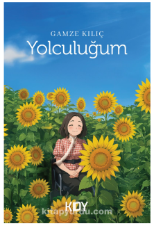 Görselde, Yolculuğum isimli kitap kapağı yer alıyor. Kitap kapağındaki görsel çizgisel; tekerlekli sandalyede oturan, gülümseyen genç bir kadın, etrafı ayçiçekleriyle çevrili bir tarlada gökyüzüne bakıyor. Ayçiçekleri sarı ve canlı, gökyüzü açık mavi ve bulutlu. Kadın, kareli kırmızı-beyaz bir gömlek giymiş.